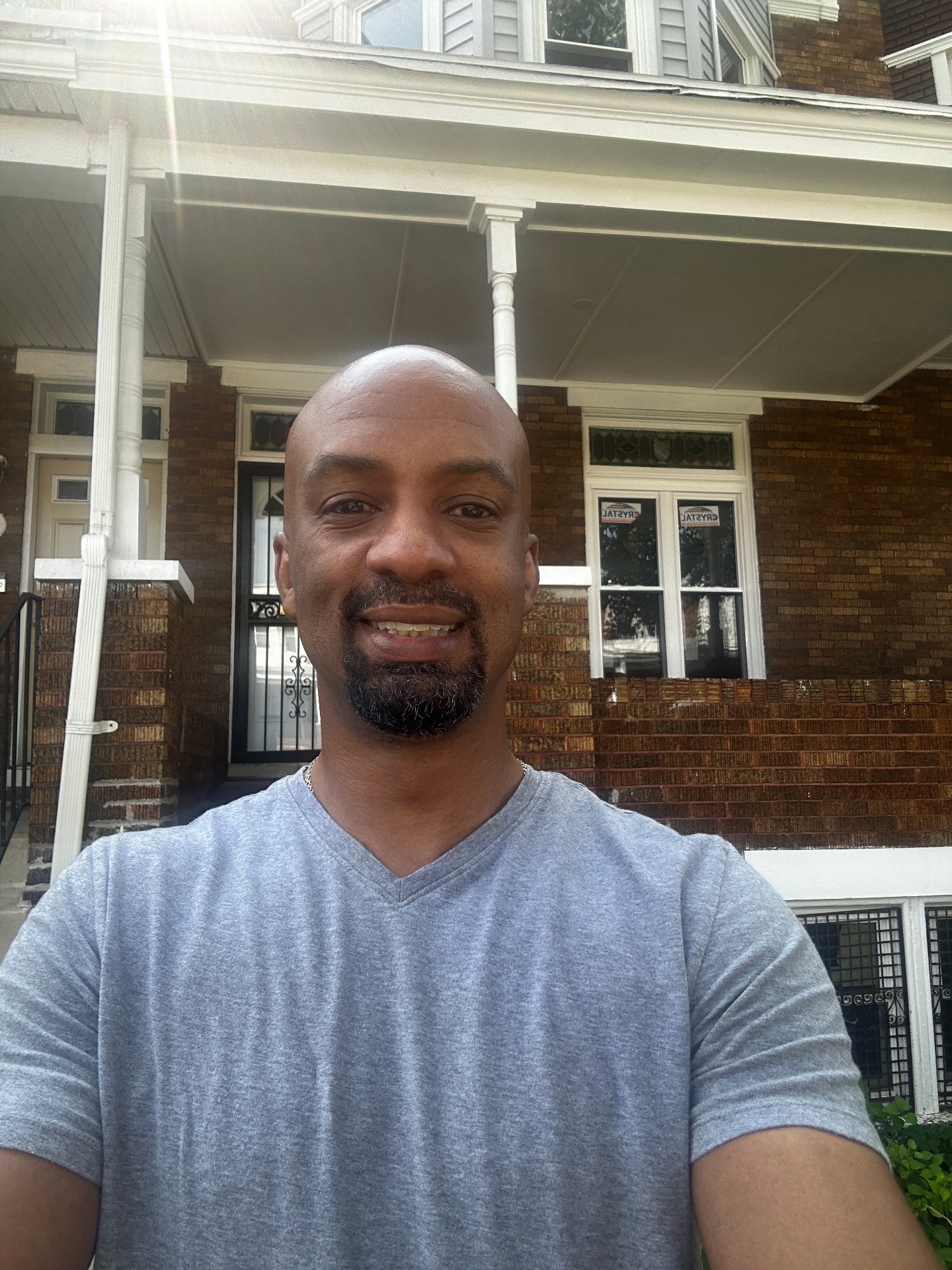 Thomas Collins, founder of ShiftRich, in front of a brick duplex